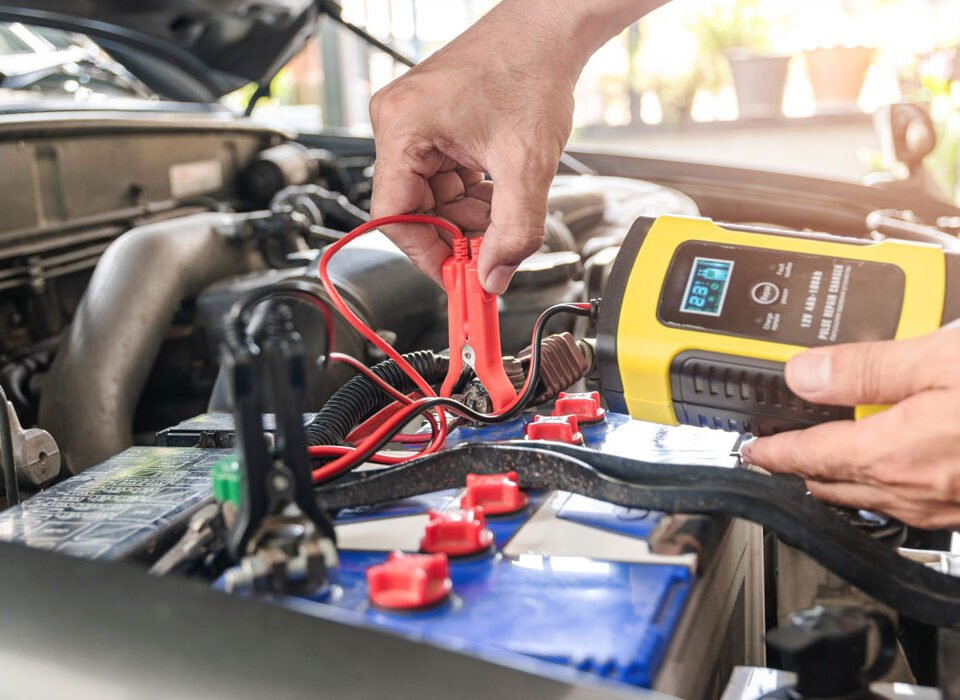 A mechanic checking on a car battery