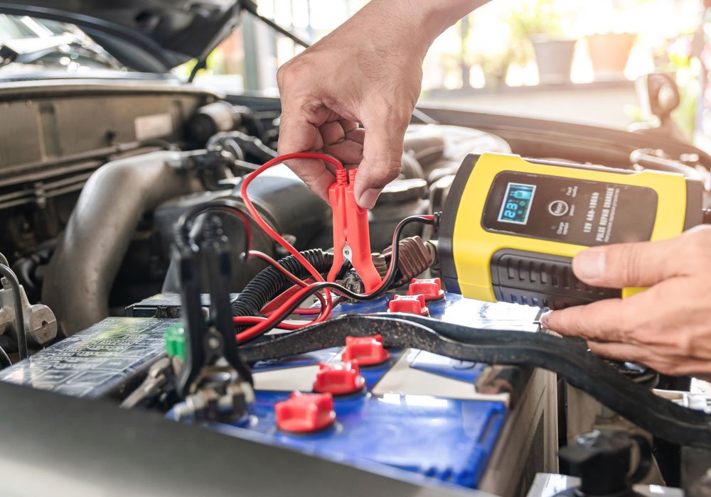 A mechanic checking on a car battery