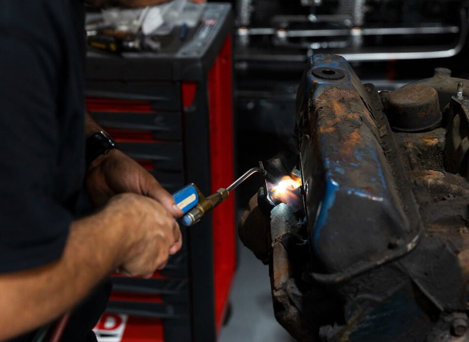 A mechanic welding a vehicle