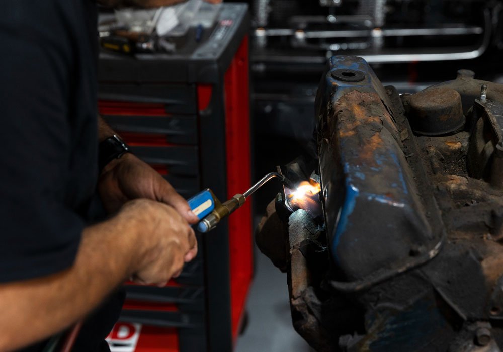 A mechanic welding a vehicle